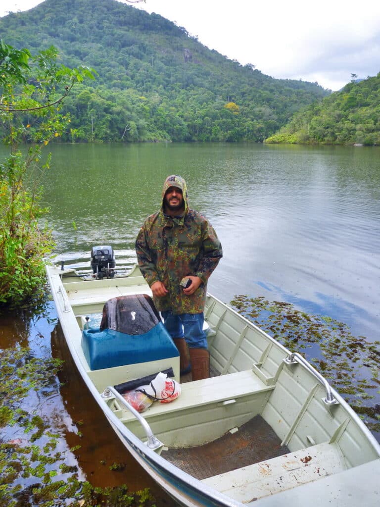 Leonardo Merçon se prepara para uma expedição de barco na Represa da Reserva Biológica de Duas Bocas sob chuva.